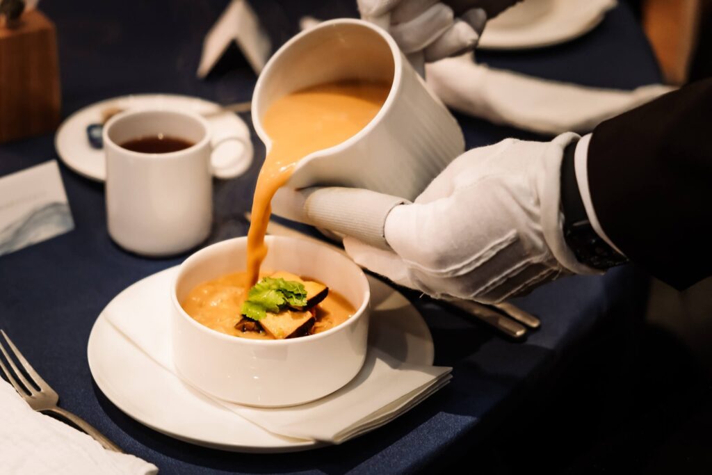 Eleganckie serwowanie zupy do półmiska podczas przyjęcia weselnego – profesjonalna obsługa i dbałość o każdy detal w athotel35.